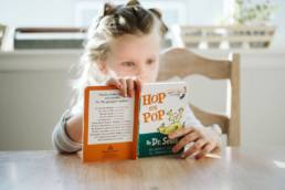 young girl reading book at the table